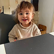 Meilya participe au concours pour gagner de l'argent avec cette photo : bangs, brown_hair, chair, child, cute, door, face, furniture, happy, indoor, portrait, smile, smiling, sweater, table, tablet, tabletop, teeth, toddler, window
