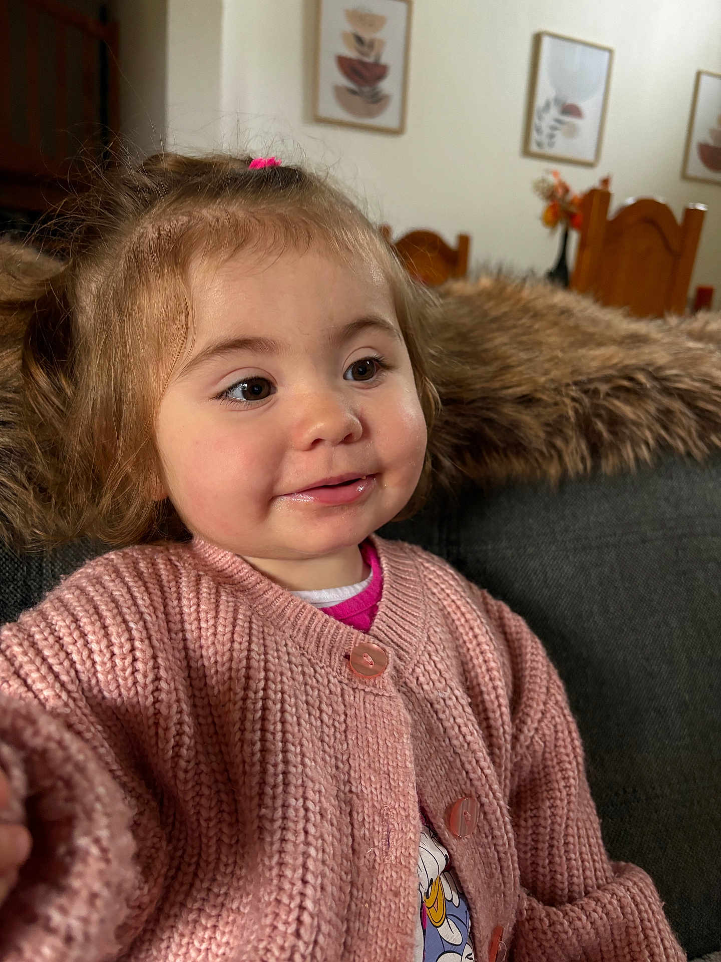 Meilya a rejoint le concours — aidez-le/la à gagner de superbes lots ! toddler, child, pink_sweater, knitted_clothing, smiling, face, portrait, couch, blanket, indoor, home_decor, wooden_chair, furniture, curly_hair, happy, baby, cozy, casual_clothing, person, seated