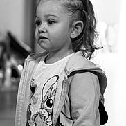 Elena a rejoint le concours — aidez-le/la à gagner de superbes lots ! child, toddler, portrait, black_and_white, braided_hair, pony_tail, jacket, cartoon_tshirt, indoor, person, face, expression, young_child, cute, clothing, standing, looking_away, soft_focus, monochrome, casual