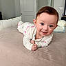 baby, child, infant, smiling, happy, portrait, tummy_time, lying_down, bed, bedroom, bedding, pajamas, onesie, brown_hair, blue_eyes, indoors, home, cozy, cute, photography