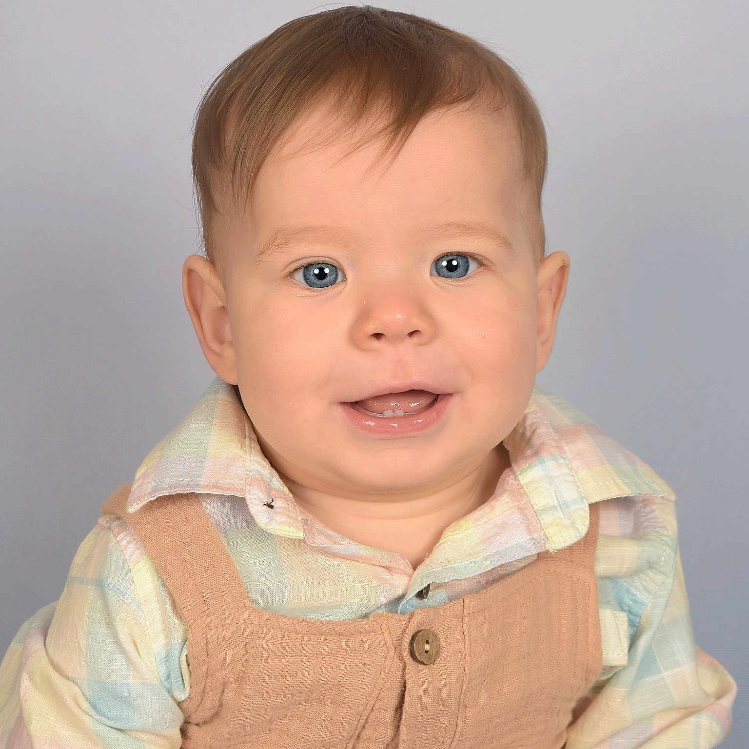 Liam is registered to the contest to win money with this photo: baby, blue_eyes, child, clothing, cute, face, happy, head_and_shoulders, indoors, infant, light_background, overalls, person, plaid_shirt, portrait, short_hair, small_teeth, smiling, studio_photo, young_child