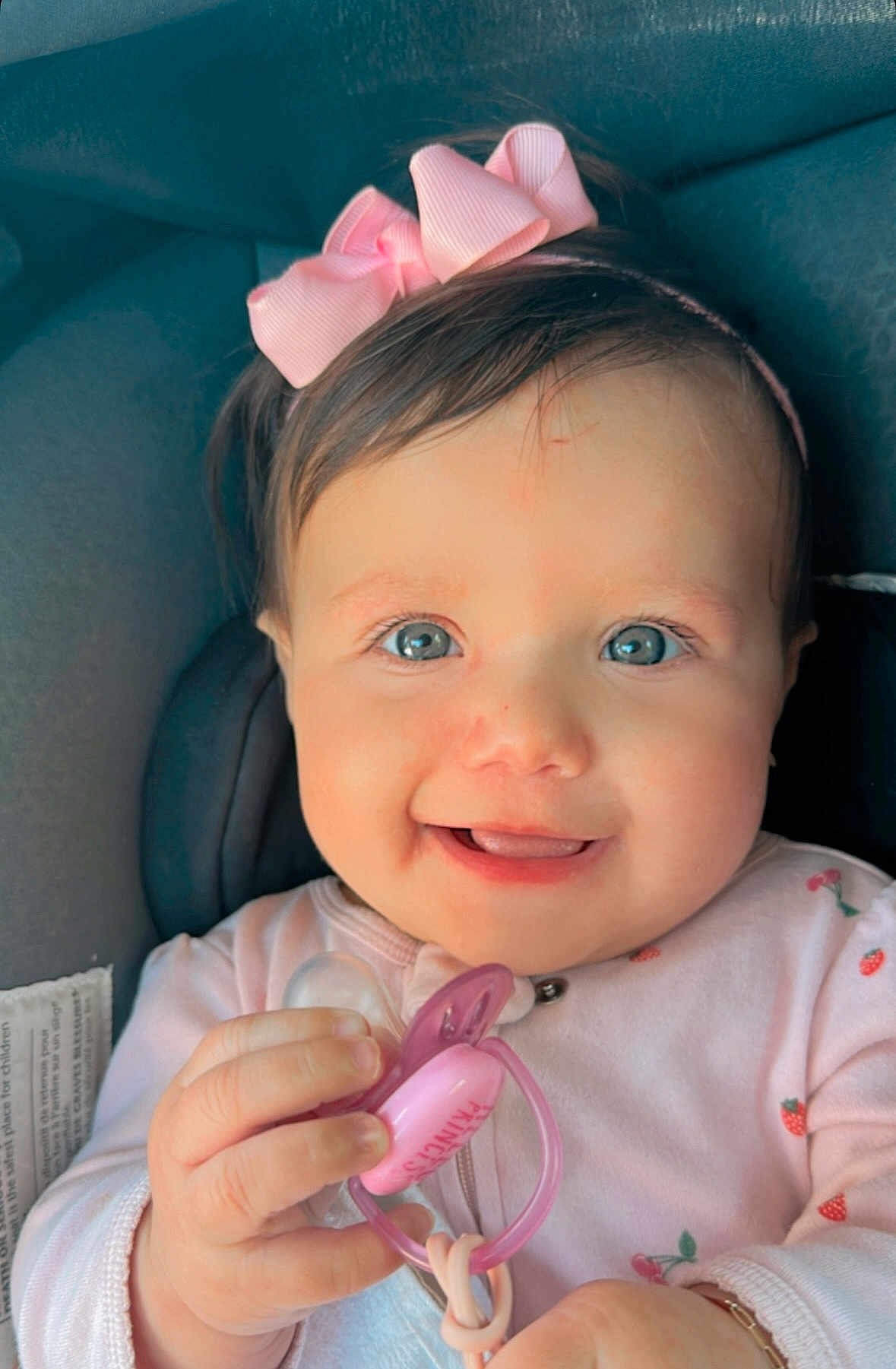 Laura joined the competition — help win amazing prizes! baby, infant, smiling, pacifier, pink_bow, blue_eyes, car_seat, child, cute, happy, portrait, hand, clothing, headband, closeup, face, girl, indoor, young_child, holding