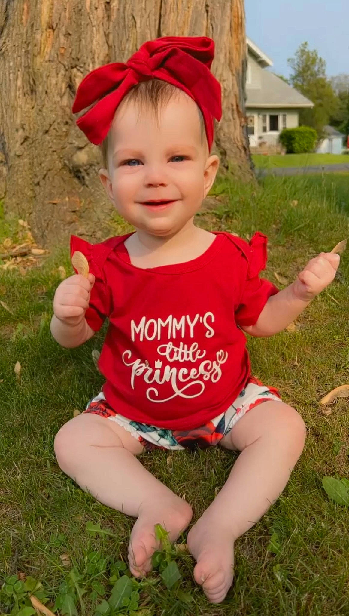 Freyja is registered to the contest to win money with this photo: baby, baby_toddler_clothing, cap, eye, face, finger, fun, grass, happy, head, human_body, joy, leisure, people_in_nature, person, pink, plant, sleeve, smile, t_shirt