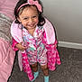 bed, bedroom, blanket, carpet, child, clothing, cute, happy, headband, indoor, pajamas, person, pink, pink_bow, playful, robe, smiling, standing, toddler, young_child
