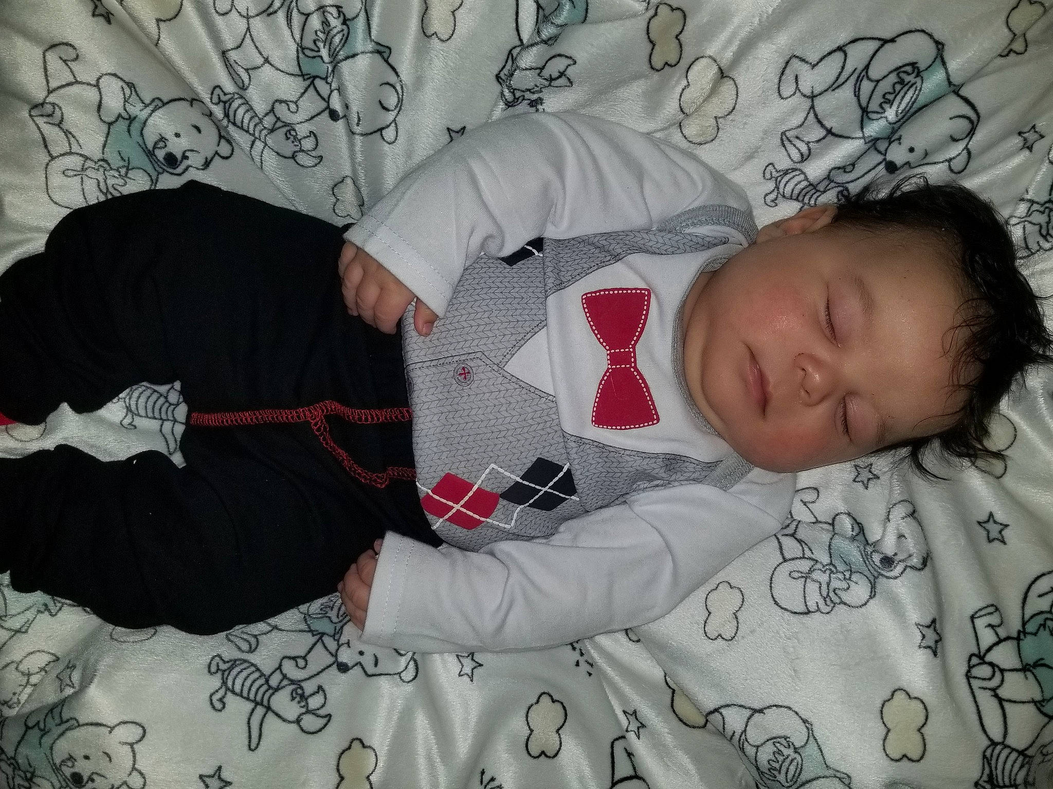 Kashton is registered to the contest to win money with this photo: arm, baby_toddler_clothing, bedding, carmine, child, comfort, couch, grey, hand, lap, linens, mammal, nap, pattern, person, room, sleeve, t_shirt, thigh, toddler