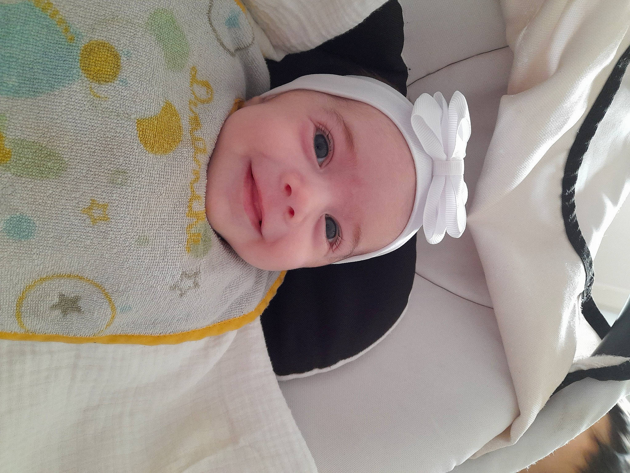 Louna participe au concours pour gagner de l'argent avec cette photo : baby, baby_products, baby_safety, baby_toddler_clothing, child, comfort, hat, headwear, linens, outerwear, pattern, person, room, skin, sleeve, smile, textile, toddler, white