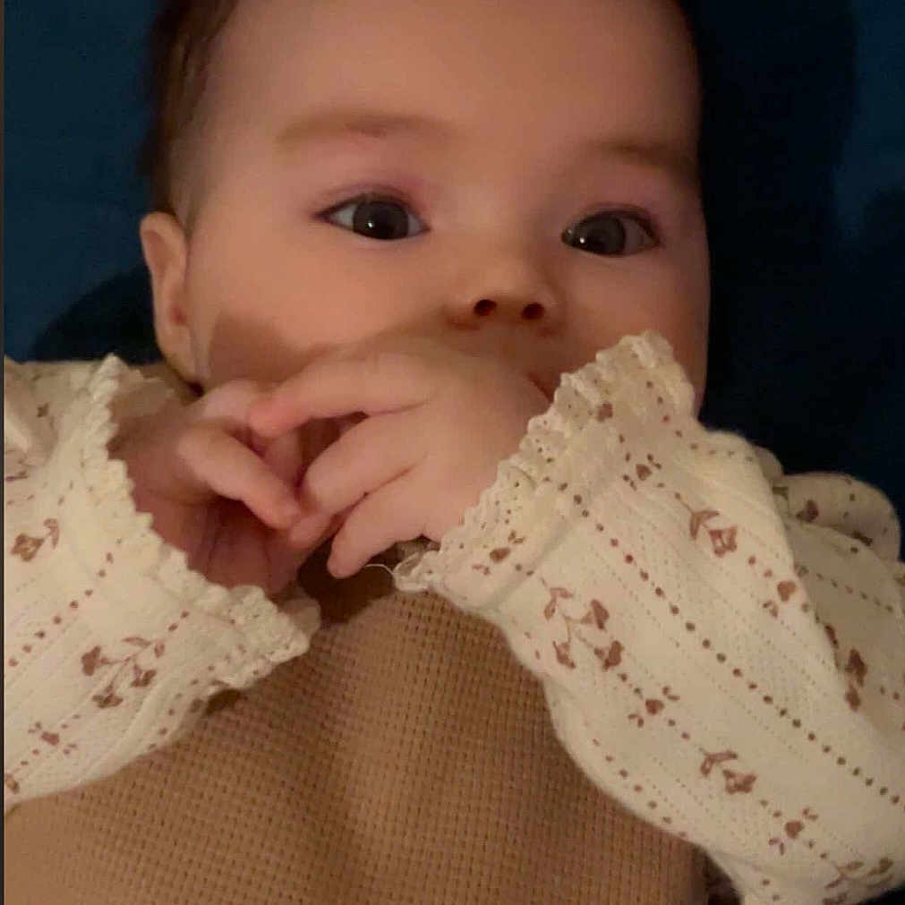 Liza participe au concours pour gagner de l'argent avec cette photo : baby, infant, child, face, hands, clothing, beige, floral, pattern, long_sleeve, cute, lying_down, portrait, young, skin, eyes, expression, soft_light, indoor, background