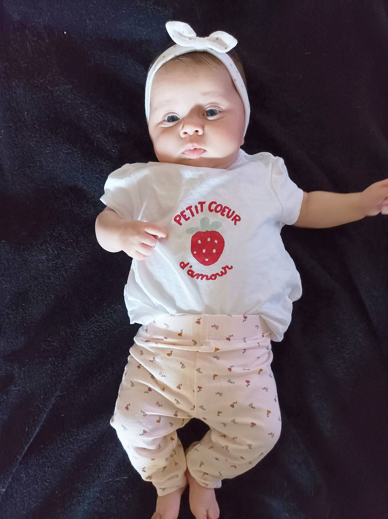 Mia participe au concours pour gagner de l'argent avec cette photo : baby, baby_products, baby_toddler_clothing, cap, cheek, costume, eye, face, fashion_accessory, gesture, happy, hat, head, outerwear, pattern, person, pink, sleeve, t_shirt, textile