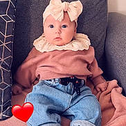 Cataleya a rejoint le concours — aidez-le/la à gagner de superbes lots ! baby, child, infant, couch, blanket, headband, bow, pink_sweater, blue_jeans, socks, heart_emoji, soft_fabric, indoor, seated, portrait, cute, wide_eyes, cozy, casual_clothing, comfortable
