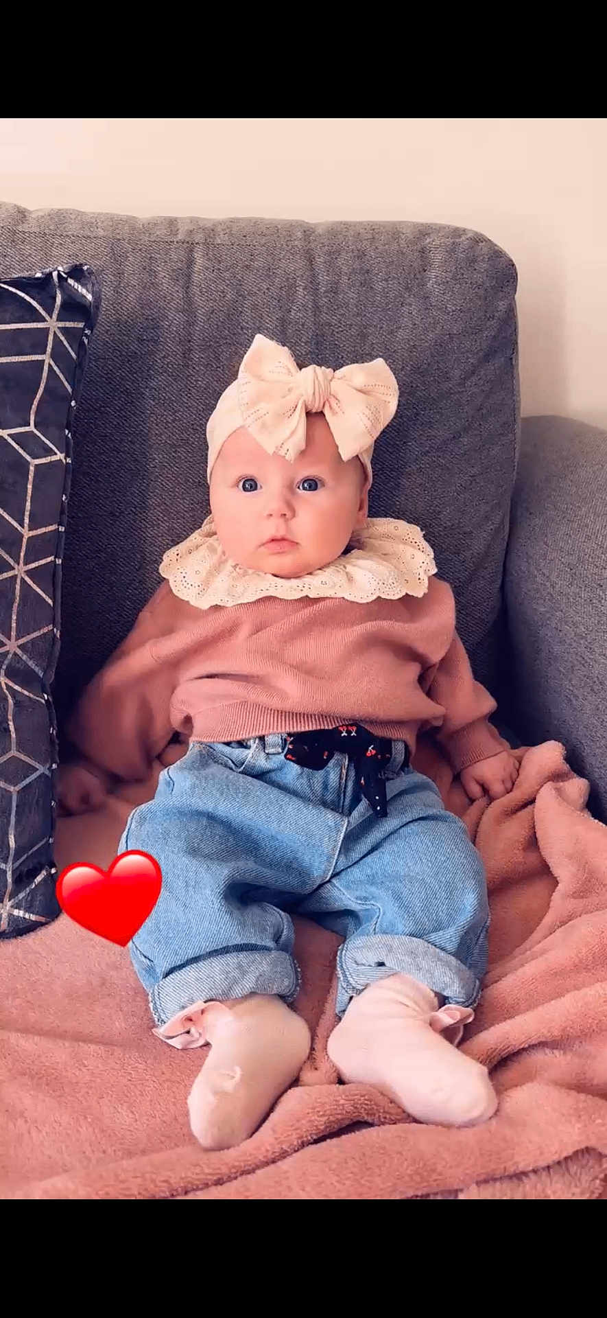 Cataleya a rejoint le concours — aidez-le/la à gagner de superbes lots ! baby, child, infant, couch, blanket, headband, bow, pink_sweater, blue_jeans, socks, heart_emoji, soft_fabric, indoor, seated, portrait, cute, wide_eyes, cozy, casual_clothing, comfortable