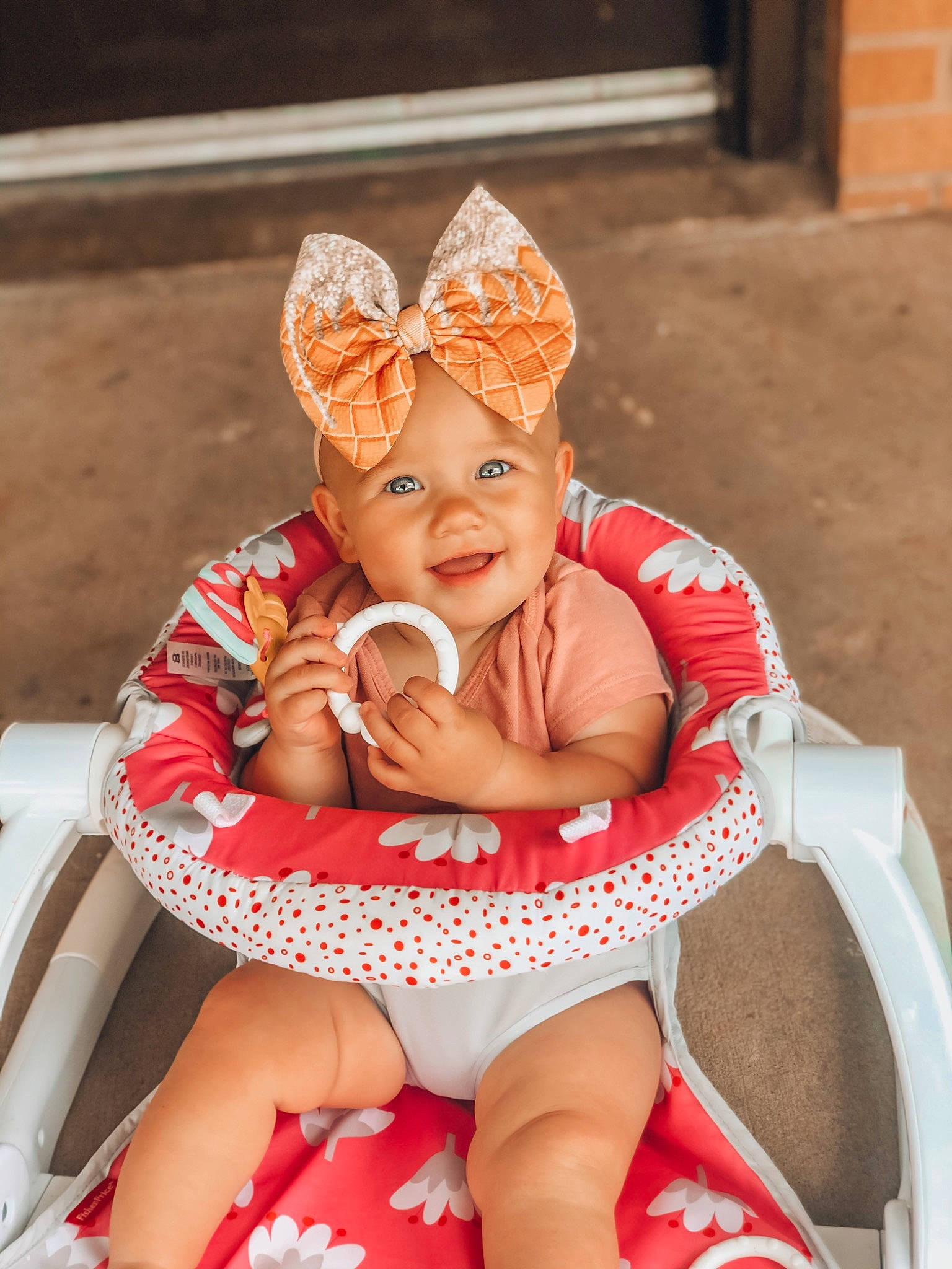 Indie is registered to the contest to win money with this photo: baby, baby_products, baby_toddler_clothing, child, ear, happy, headgear, headwear, joy, person, pink, product, red, sitting, skin, smile, toddler