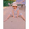 Gayané a rejoint le concours — aidez-le/la à gagner de superbes lots ! barefoot, blurred_background, casual_clothing, child, curly_hair, cute, daylight, fence, floral_dress, girl, hat, legs_spread, nature, outdoor, people_in_background, playground, sand, sitting, summer, young