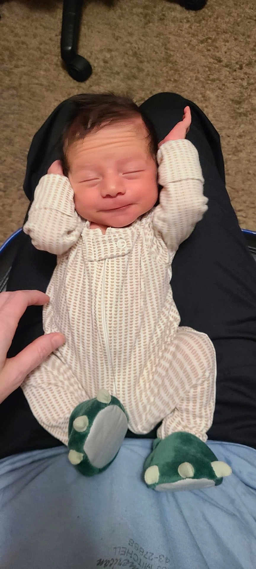 Elijah joined the competition — help win amazing prizes! baby, infant, sleeping, onesie, footwear, dinosaur_slippers, carpet, hand, lap, person, relaxing, cozy, cute, sleep, patterned_clothing, indoor, comfort, child, newborn, soft