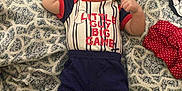 Elijah joined the competition — help win amazing prizes! baby, bed, blanket, blue_pants, blue_slippers, child, clothing, cute, cute_expression, fabric, face, flexing, indoor, infant, lying_down, pattern, person, red_shirt, small_hands, text_on_clothing