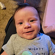 Elijah joined the competition — help win amazing prizes! baby, carpet, casual, child, clothing, cute, dinosaur_graphic, face, grey_shirt, hair, happy, indoor, infant, lap, person, portrait, short_sleeves, sitting, smiling, toddler