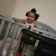A'Zyriah is registered to the contest to win money with this photo: toddler, child, crib, baby, smiling, happy, indoor, bedroom, blanket, furniture, hair, person, infant, sleeping_area, toy, playful, grip, cute, home, young_child