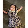 baby, infant, child, plaid_dress, headband, couch, fabric, cute, eyes, portrait, laying_down, hands, expression, indoor, person, clothing, texture, young_child, smile, sleeves