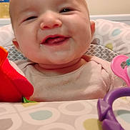 Raelynn joined the competition — help win amazing prizes! baby, smile, high_chair, toy, infant, face, child, happy, pattern, clothing, indoor, cute, closeup, person, playtime, colorful, pink, purple, red, seat