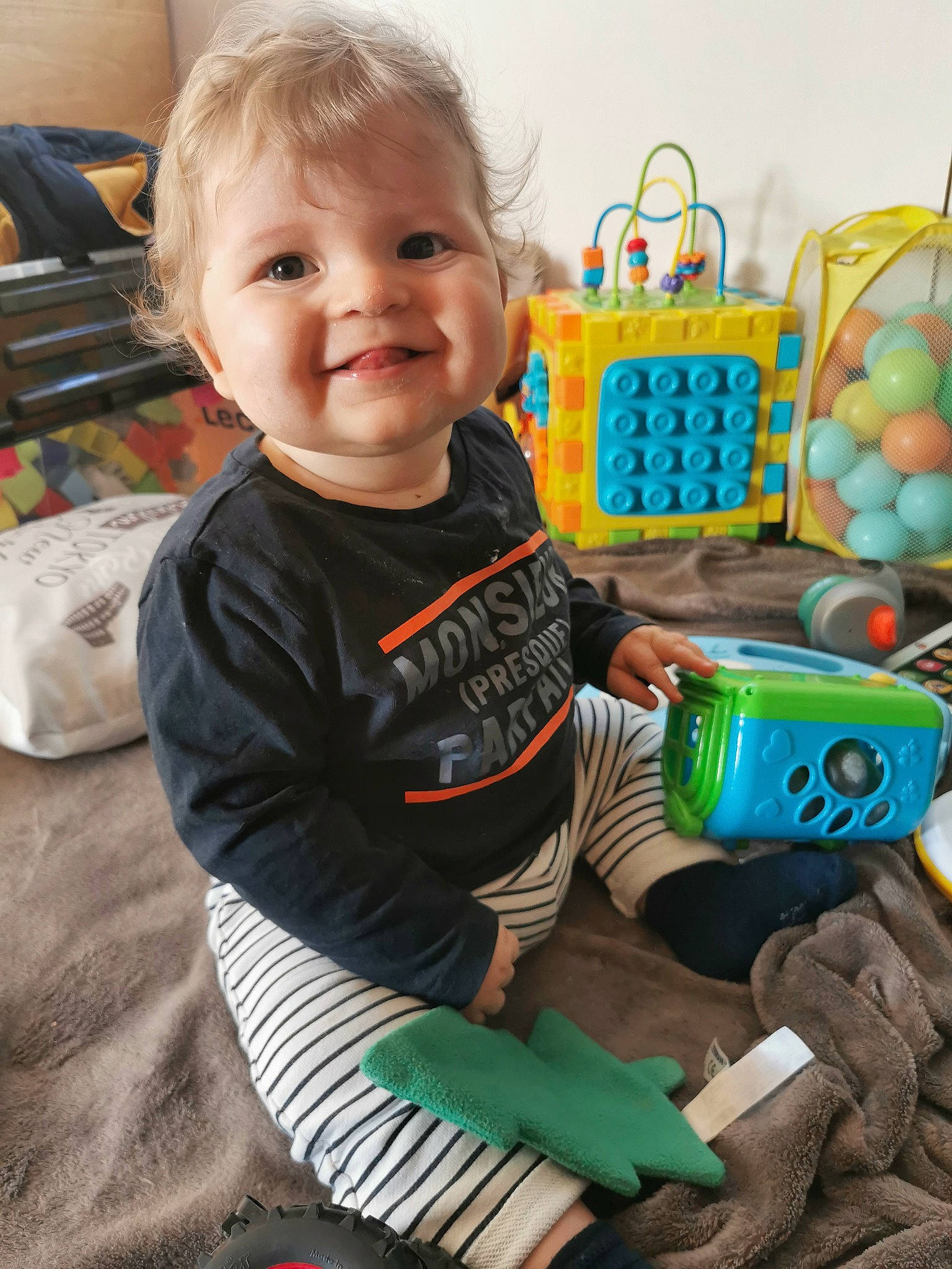 Denzo participe au concours pour gagner de l'argent avec cette photo : baby, baby_toddler_clothing, bag, basket, child, face, fun, green, happy, head, joy, person, play, product, room, sitting, sleeve, smile, sock, t_shirt