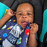 Auren is registered to the contest to win money with this photo: baby, child, car_seat, straps, space_theme, planets, rocket, clothing, smile, happy, infant, cute, hand, face, seatbelt, toddler, portrait, closeup, indoor, playful