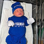 Lino a rejoint le concours — aidez-le/la à gagner de superbes lots ! newborn, baby, sleeping, blue_clothing, hat, mittens, socks, bassinet, hospital, blanket, soft_lighting, infant, cute, portrait, babywear, resting, child, person, young, indoors