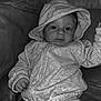 baby, child, hoodie, clothing, couch, leather, indoor, portrait, infant, person, sitting, cute, face, expression, monochrome, black_and_white, cozy, young, relaxed, casual