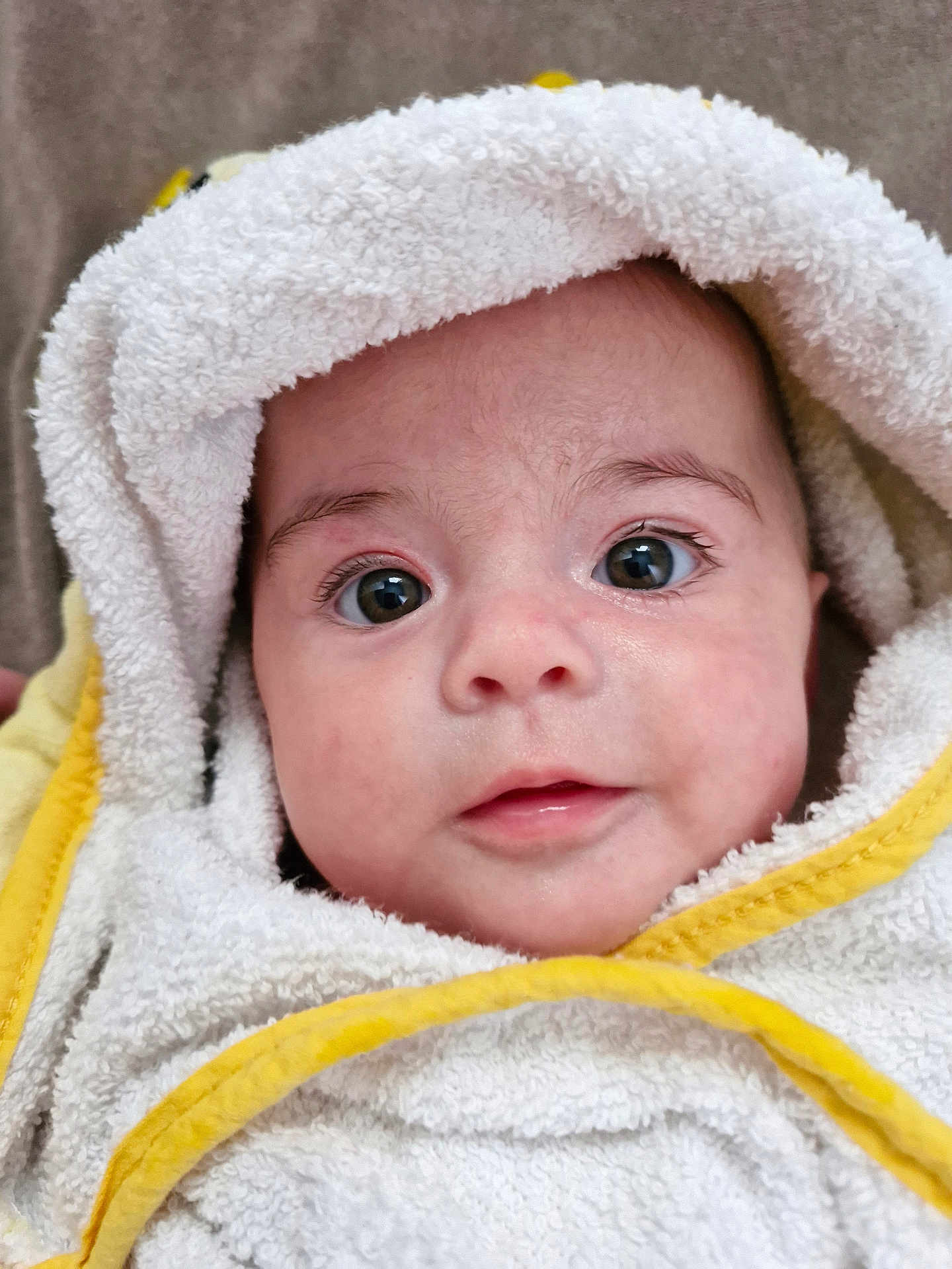 Alba participe au concours pour gagner de l'argent avec cette photo : baby, infant, face, eyes, towel, hooded_towel, white, yellow, skin, closeup, portrait, cute, child, newborn, soft_texture, expression, wrapped, indoors, head, person