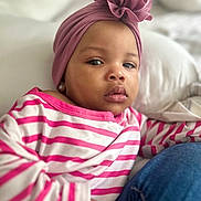 Chakayla is registered to the contest to win money with this photo: bed, casual, child, closeup, clothing, comfort, expression, face, flower_accessory, headwear, indoor, person, pillow, pink_turban, portrait, resting, skin, striped_shirt, toddler, young_child