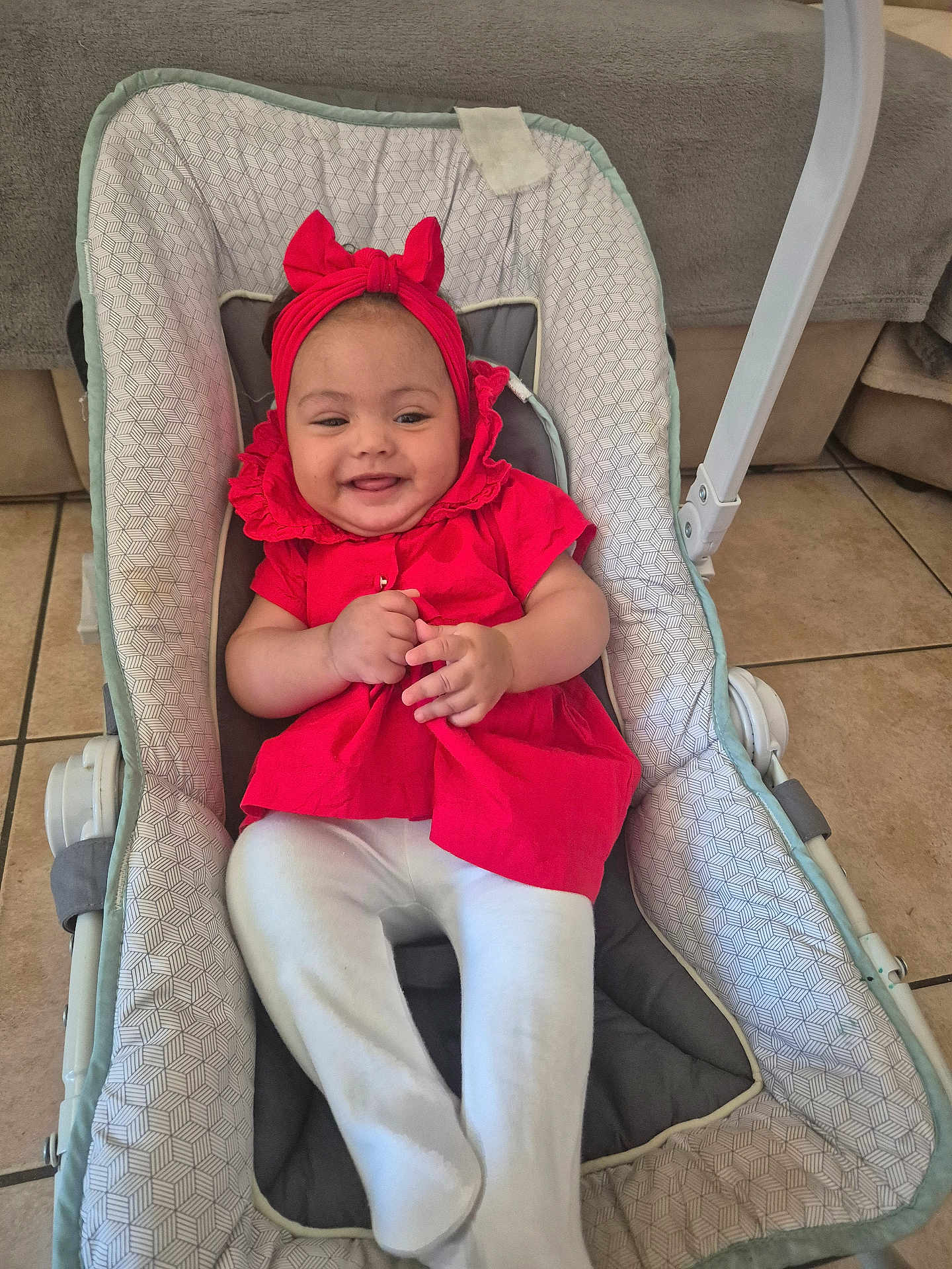 Hanna participe au concours pour gagner de l'argent avec cette photo : baby, infant, smile, red_clothing, headband, baby_seat, cushion, home_interior, tile_floor, happy, child, person, sitting, cute, playful, indoor, white_pants, fabric, comfort, portrait
