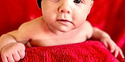 Arthur joined the competition — help win amazing prizes! baby, infant, face, hat, black_hat, red_blanket, red_background, skin, eyes, hand, cute, portrait, child, young, looking, expression, indoors, soft_texture, warm_colors, cozy