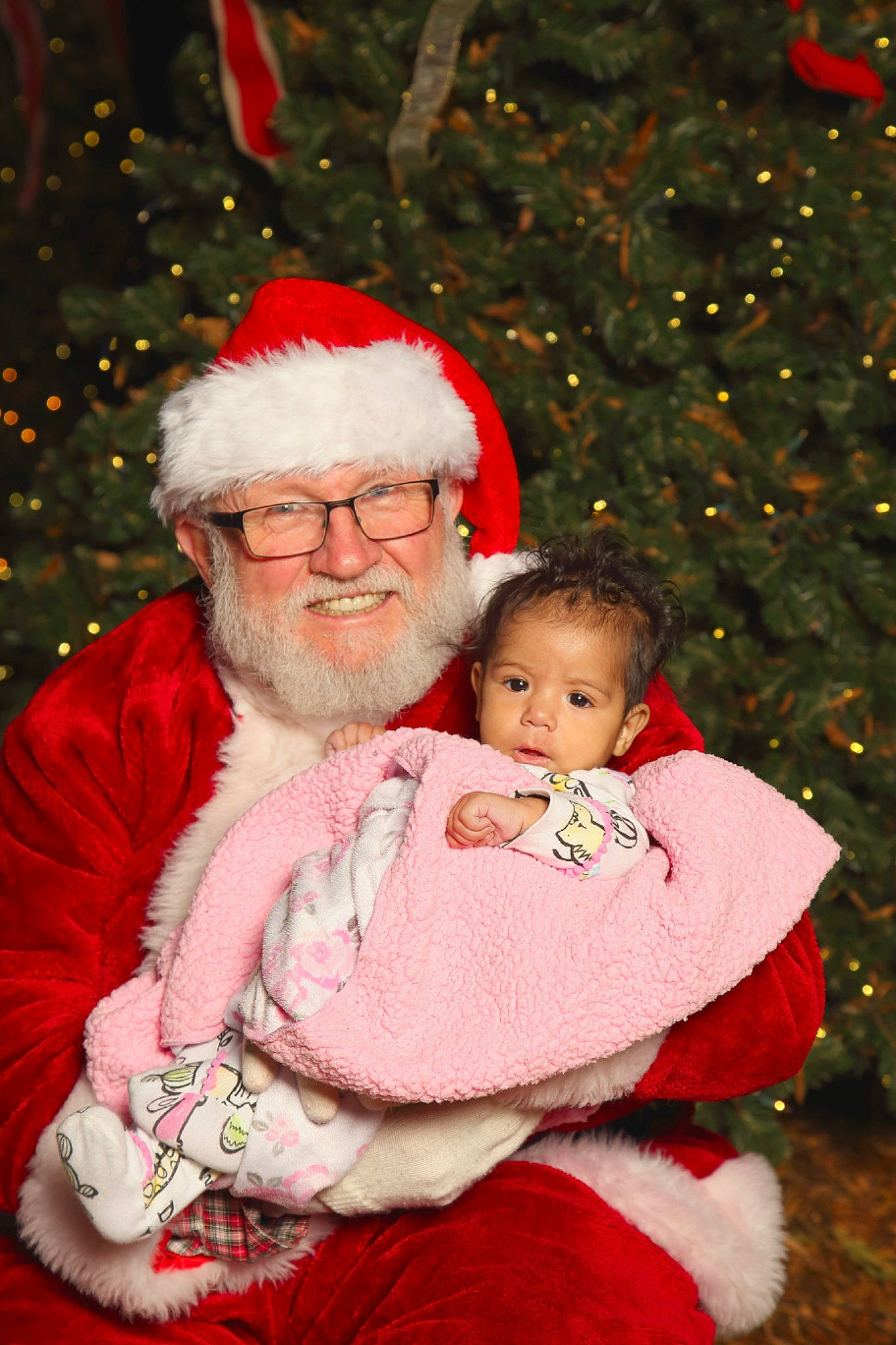 Miyah is registered to the contest to win money with this photo: baby, child, christmas, christmas_decoration, christmas_eve, christmas_lights, christmas_ornament, christmas_tree, fictional_character, happy, holiday, human_body, interior_design, joy, lap, person, santa_claus, smile, toddler