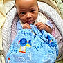 Semaj is registered to the contest to win money with this photo: baby, blanket, blue_blanket, child, clothing, comfort, cushion, cute, expression, face, hand, head, indoors, infant, looking, person, portrait, seat, soft_toys, toddler