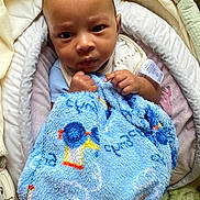 Semaj joined the competition — help win amazing prizes! baby, blanket, blue, child, clothing, comfort, cushion, expression, face, hand, indoor, infant, person, portrait, seat, soft, toddler, toy, warm, young