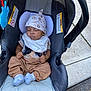 Semaj is registered to the contest to win money with this photo: animal_print, baby, bib, brown_pants, car_seat, child, clothing, cute, hat, infant, outdoor, peaceful, relaxing, resting, seat, sidewalk, sleeping, socks, toy, young_child