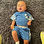 Gracen is registered to the contest to win money with this photo: baby, child, blue_clothing, checkered_pattern, toy, sock, rug, fluffy_rug, indoor, laying_down, skin, infant, cute, small_toy, relaxed, hand, footwear, head, face, person