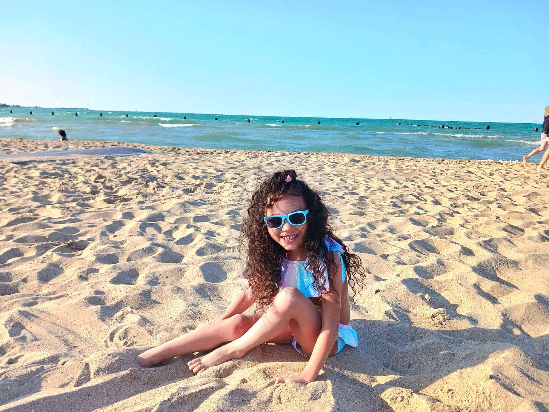 Arianna Warren is registered to the contest to win money with this photo: azure, beach, body_of_water, cloud, coastal_and_oceanic_landforms, glasses, goggles, happy, joy, leg, light, mammal, natural_environment, people_in_nature, people_on_beach, person, photograph, sky, smile, sunglasses