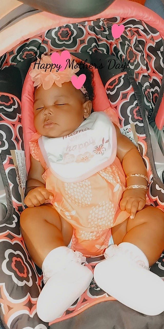 M'Lonie is registered to the contest to win money with this photo: abdomen, arm, baby, baby_toddler_clothing, cheek, chest, comfort, eyelash, finger, hand, headwear, human_body, lap, mouth, nail, person, pink, skin, thigh, thumb