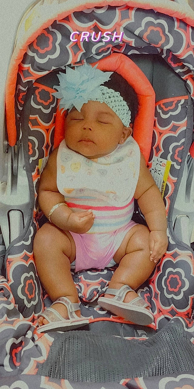 M'Lonie is registered to the contest to win money with this photo: baby, baby_carriage, baby_products, baby_sleeping, baby_toddler_clothing, cheek, child, comfort, finger, foot, headwear, lap, linens, nail, pattern, person, sitting, skin, sock, thigh