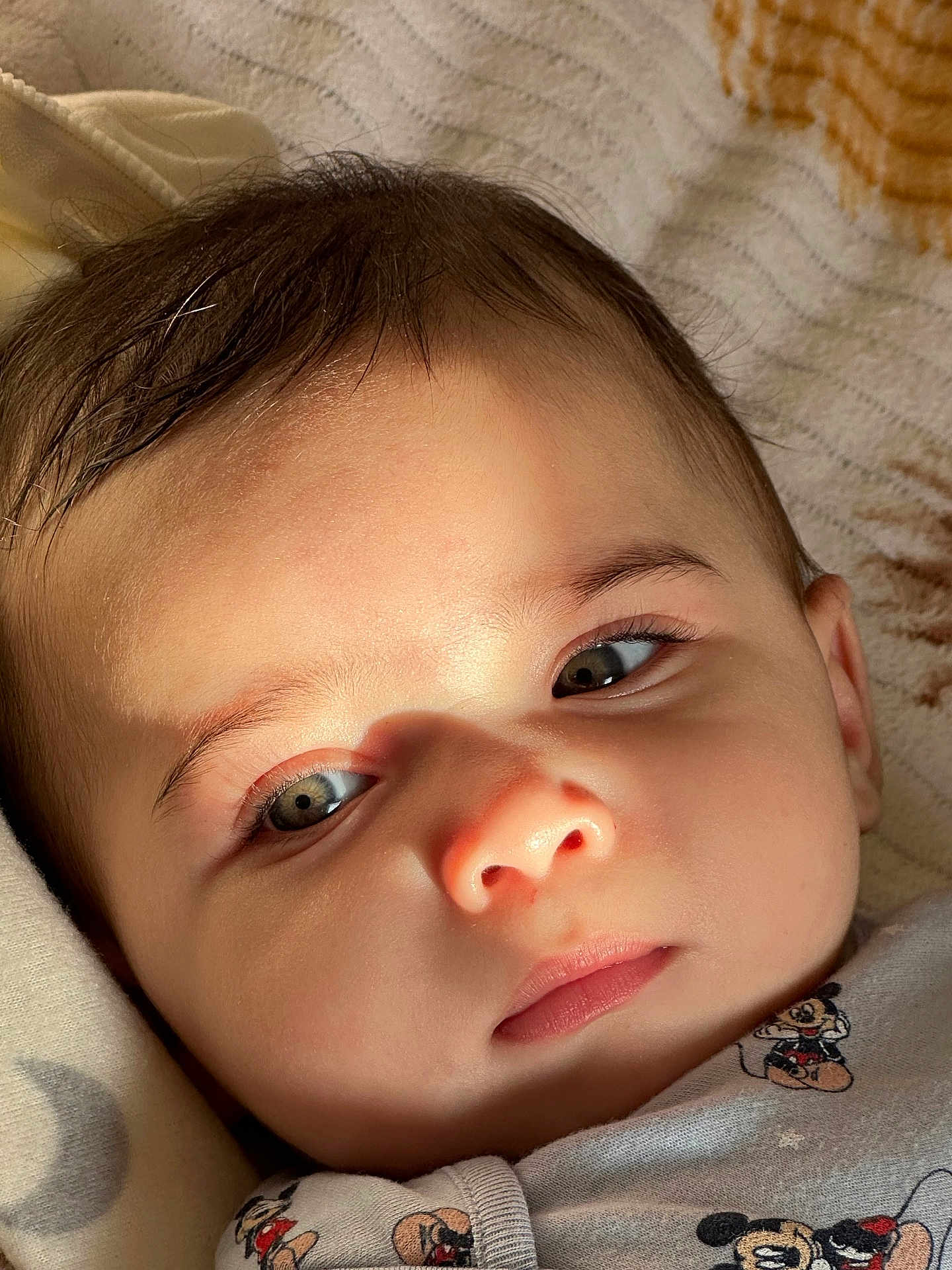 Ghali a rejoint le concours — aidez-le/la à gagner de superbes lots ! baby, infant, child, face, eyes, eyelashes, nose, lips, hair, portrait, close_up, onesie, mickey_mouse, blanket, soft_light, sunlight, shadow, skin, cute, adorable