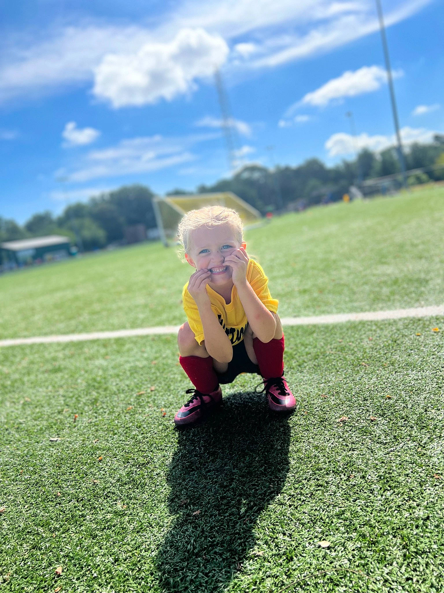 Katie joined the competition — help win amazing prizes! ball, cloud, football, grass, grassland, happy, knee, landscape, leg, leisure, meadow, people_in_nature, person, plant, player, playing_sports, sky, sneakers, sports_equipment, sunlight