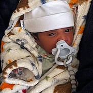 Brycen is registered to the contest to win money with this photo: newborn, baby, infant, child, portrait, face, eyes, pacifier, hat, blanket, fleece, bundled, sleeping, cozy, indoors, close_up, baby_clothing, swaddled, cute, photography