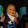 baby, smiling, car_seat, pacifier, bib, child, infant, happy, seatbelt, clothing, cute, indoor, person, young_child, sitting, face, hand, toy, expression, safety