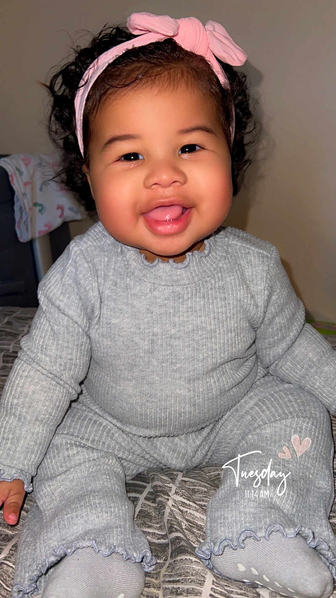 Leila is registered to the contest to win money with this photo: accessories, baby, bodypart, clothing, couch, face, finger, furniture, hand, happy, hat, head, headband, knitwear, longsleeve, person, photography, portrait, smile, sweater