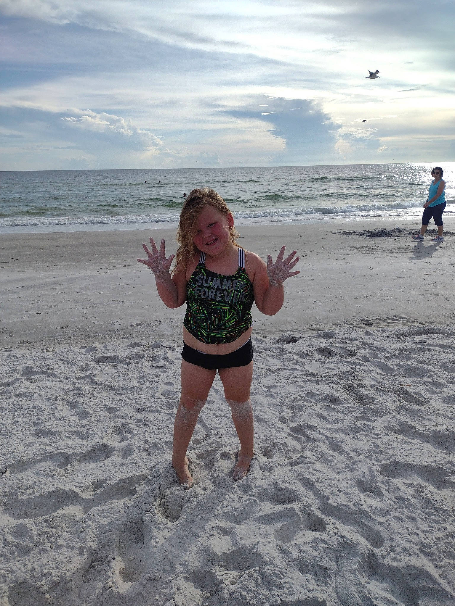 Madilyn is registered to the contest to win money with this photo: azure, beach, cloud, coastal_and_oceanic_landforms, fun, happy, holiday, horizon, joy, natural_environment, people_on_beach, person, sand, shore, sky, smile, swimwear, thigh, toddler, vertebrate