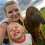 Daisy joined the competition — help win amazing prizes! woman, child, dog, grass, outdoor, sky, clouds, smile, portrait, casual, nature, happy, pet, family, tattoo, earrings, blonde_hair, green_grass, daylight, playful