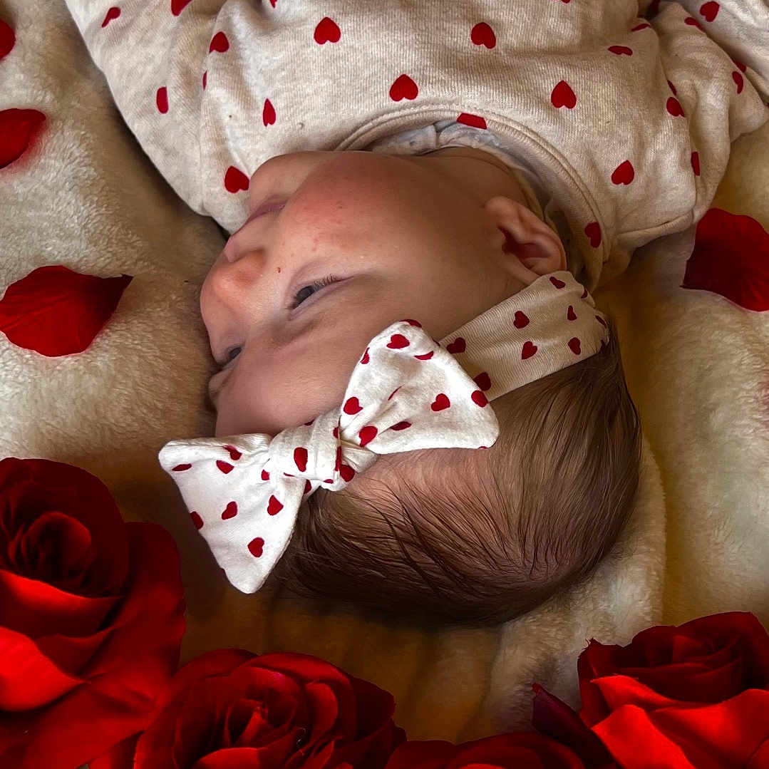 Kaylie a rejoint le concours — aidez-le/la à gagner de superbes lots ! adorable, baby, blanket, bow, closeup, fabric, flower_petals, gazing, headband, heart_pattern, infant, love_theme, lying_down, newborn, onesie, portrait, red_roses, resting, roses, soft_texture