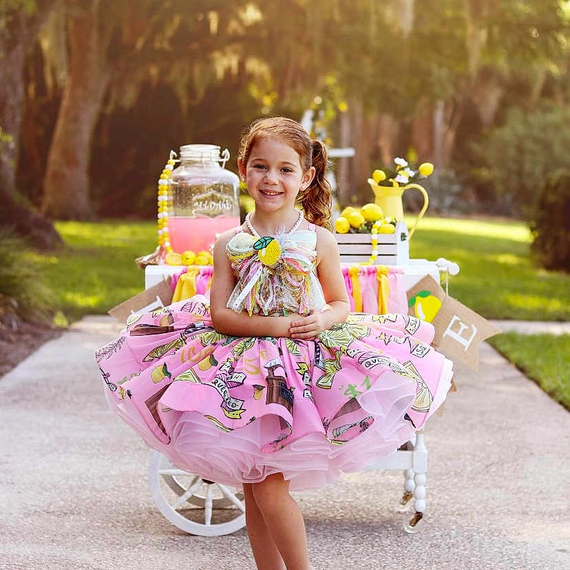 Megan joined the competition — help win amazing prizes! child, clothing, costume, dress, face, female, girl, grass, head, jar, nature, outdoors, person, photography, plant, portrait, sitting, skirt, summer, vegetation