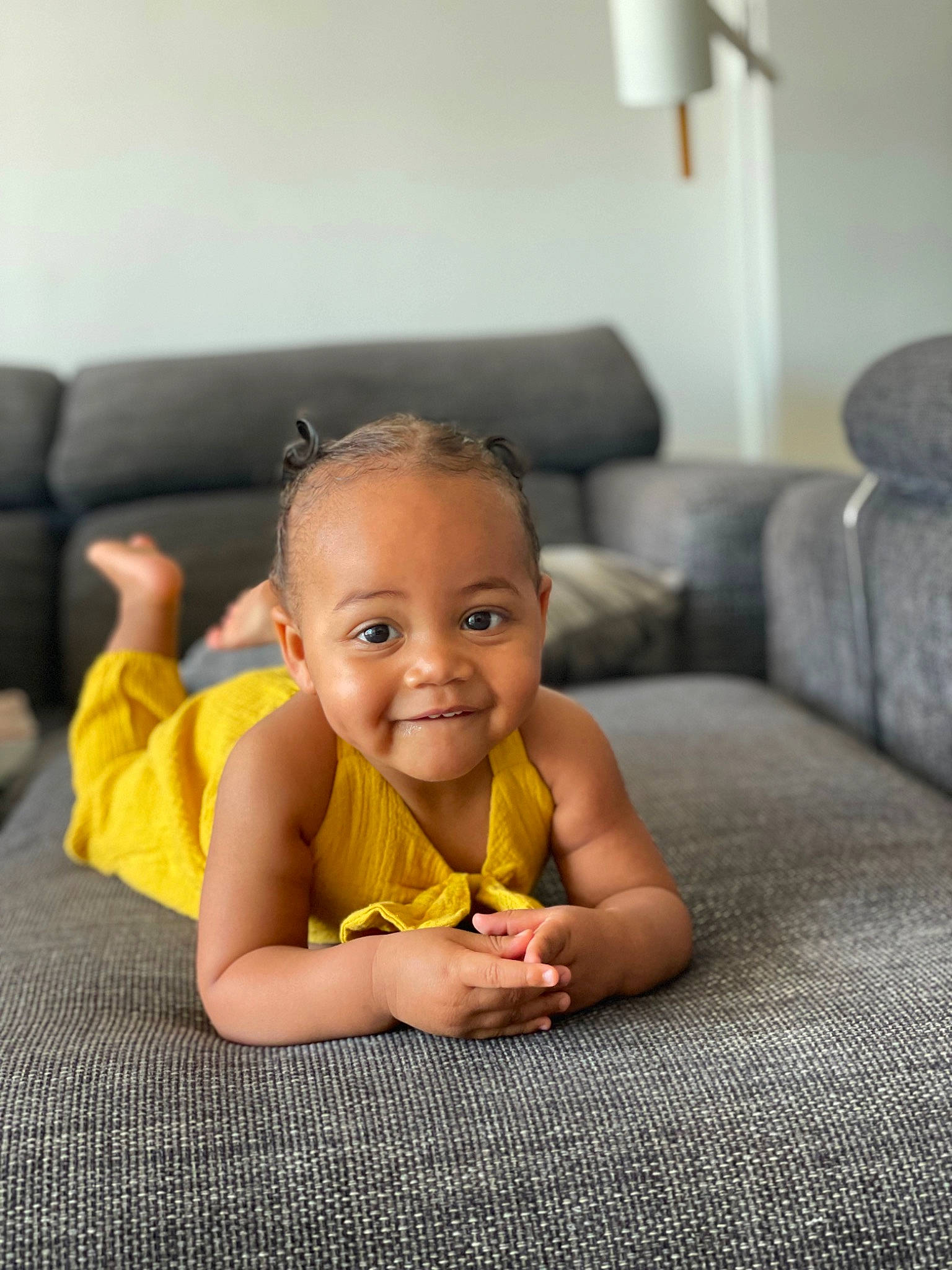 Zoé participe au concours pour gagner de l'argent avec cette photo : arm, baby, baby_toddler_clothing, cheek, child, comfort, couch, finger, flash_photography, floor, flooring, fun, happy, hardwood, joy, living_room, person, room, sitting, skin