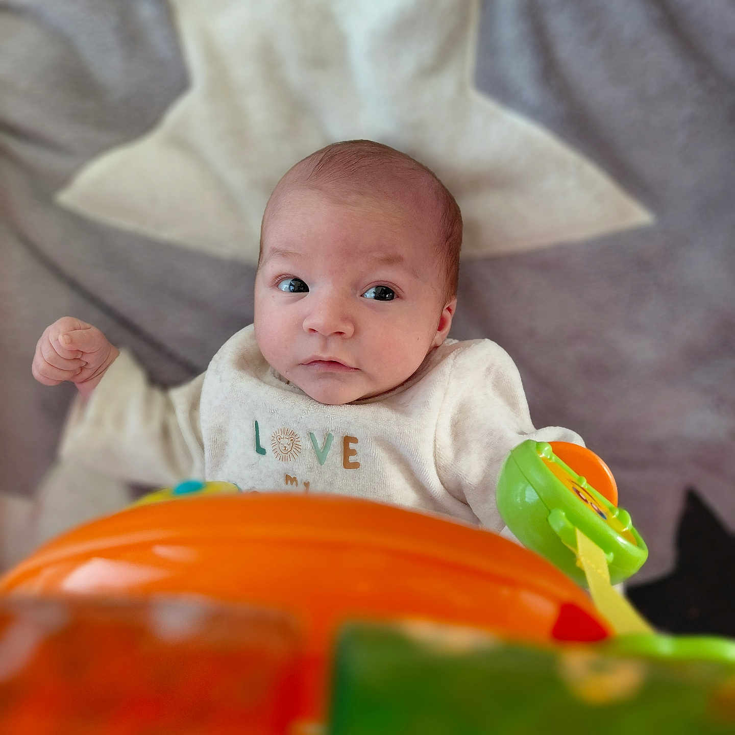 Maëcio a rejoint le concours — aidez-le/la à gagner de superbes lots ! baby, blanket, child, clothing, colorful, comfort, cute, early_life, expression, face, focus, indoor, infant, lying_down, newborn, person, play, soft, star_pattern, toy