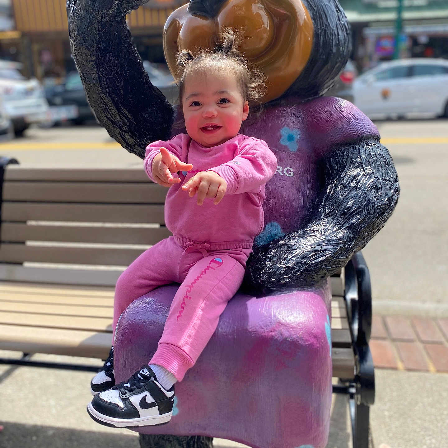 Leilah is registered to the contest to win money with this photo: baby, bench, car, city, clothing, face, footwear, furniture, head, pants, person, photography, portrait, road, shoe, sneaker, street, transportation, urban, vehicle